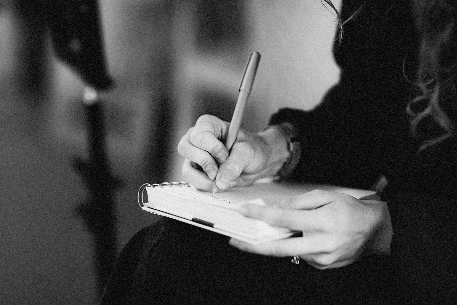Black and white photo of hands with a notebook